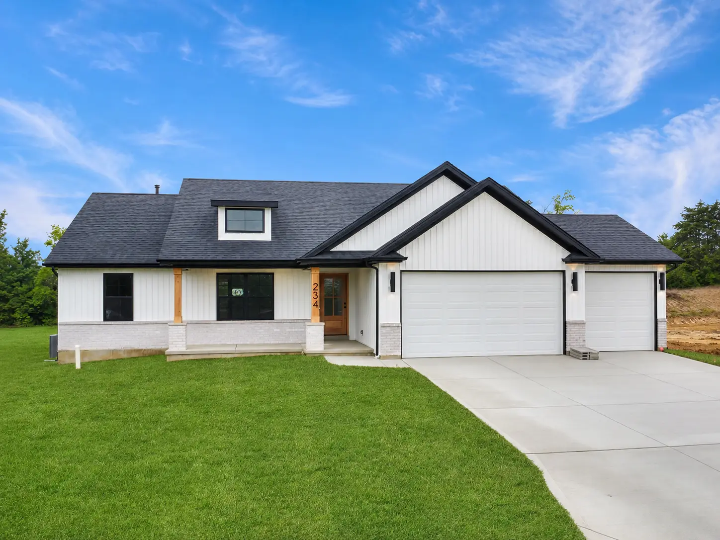 White modern farmhouse with black-trimmed gables and attached two- and single-car garages.
